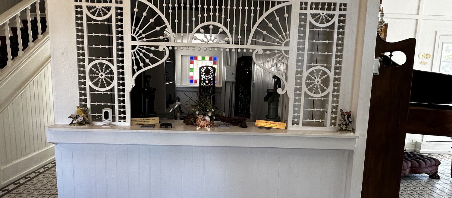 The welcome area inside, beneath the original 1887 lobby screen of white spindle and ball fretwork